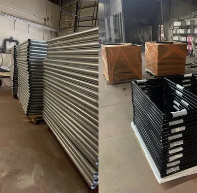Stacks of finished metal rails and black fabricated components in the Clark's shop