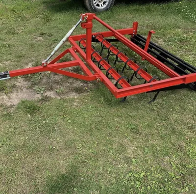 Bright red powder-coated agricultural implement photographed outdoors