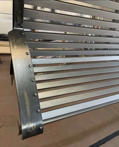 Weathered metal park bench before final powder-coated restoration