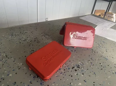 Two red Snap-on metal cases showing worn and refreshed finish condition