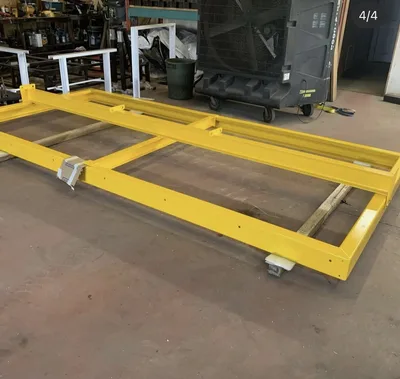 Large yellow powder-coated fabricated equipment frame in the Clark's shop