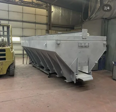 Large grey powder-coated industrial hopper or bin inside the Clark's shop