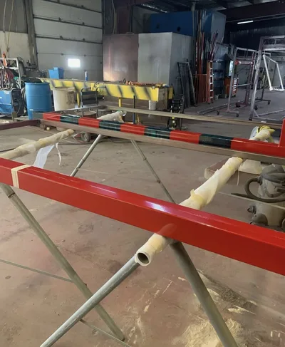Long bright red powder-coated metal rails supported in the Clark's shop
