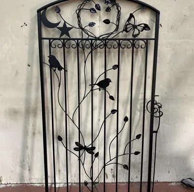 Black decorative metal garden gate with birds, vines and moon details