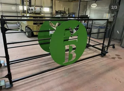 Black powder-coated gate with green circular custom logo panel
