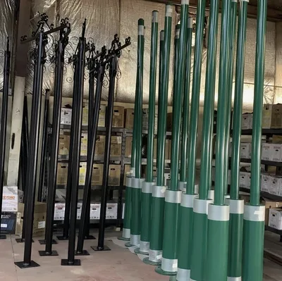 Rows of finished black decorative posts and green-and-white poles in the shop