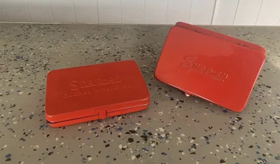 Two bright red powder-coated Snap-on metal cases after refinishing