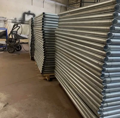 Large stacks of bare tubular metal frames before finishing