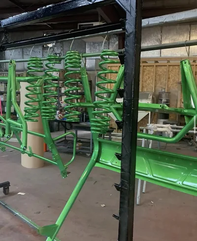 Bright green powder-coated equipment frame with coil springs in the shop