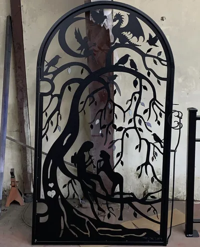 Black powder-coated decorative gate with detailed fantasy and wildlife cutout artwork