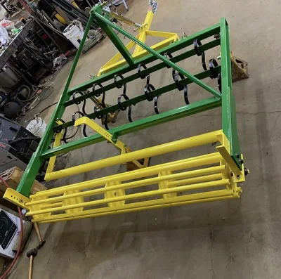 Green and yellow powder-coated agricultural equipment frame in the shop